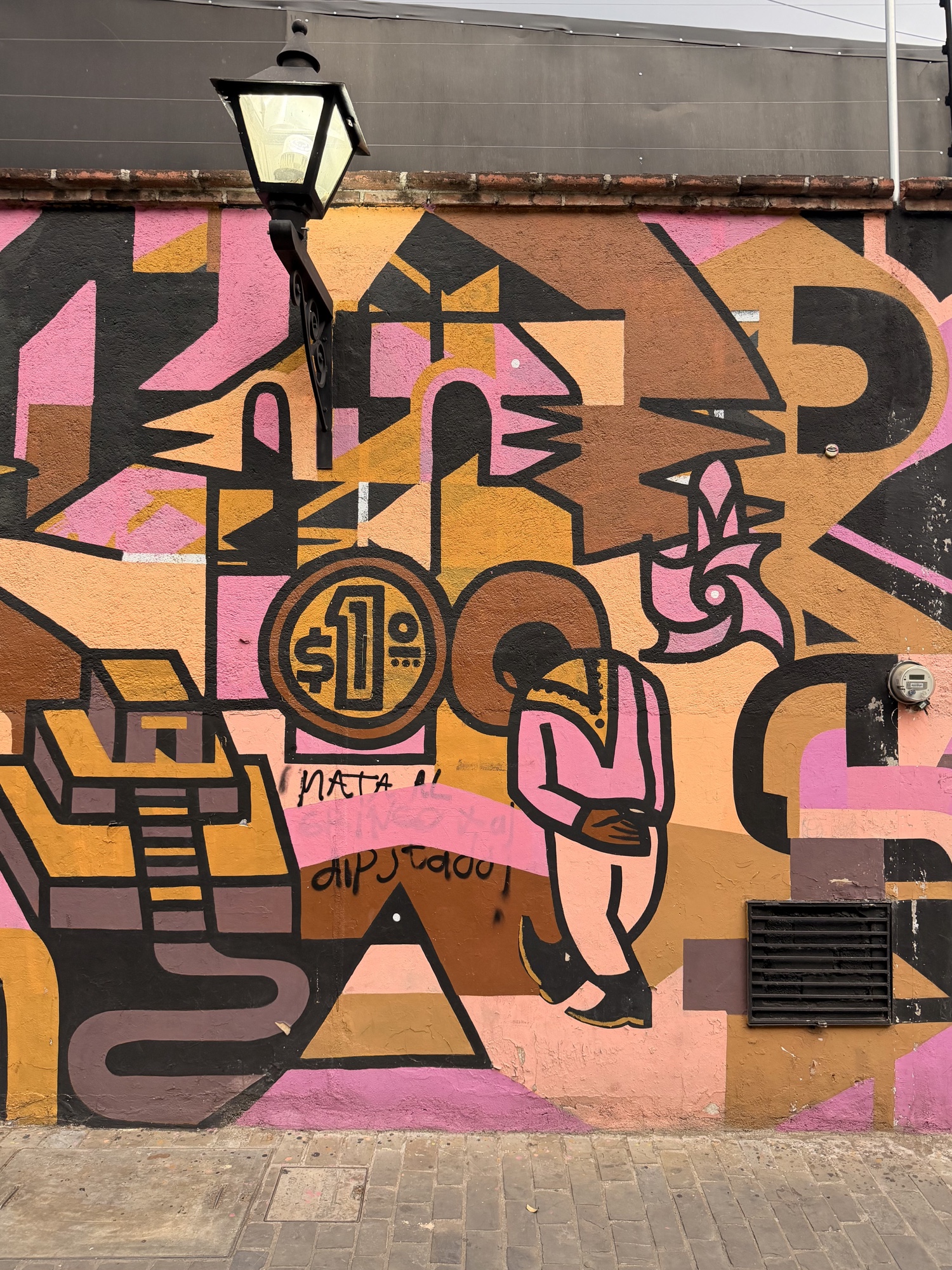 Pink, ochre, and black geometric street mural photographed in Oaxaca