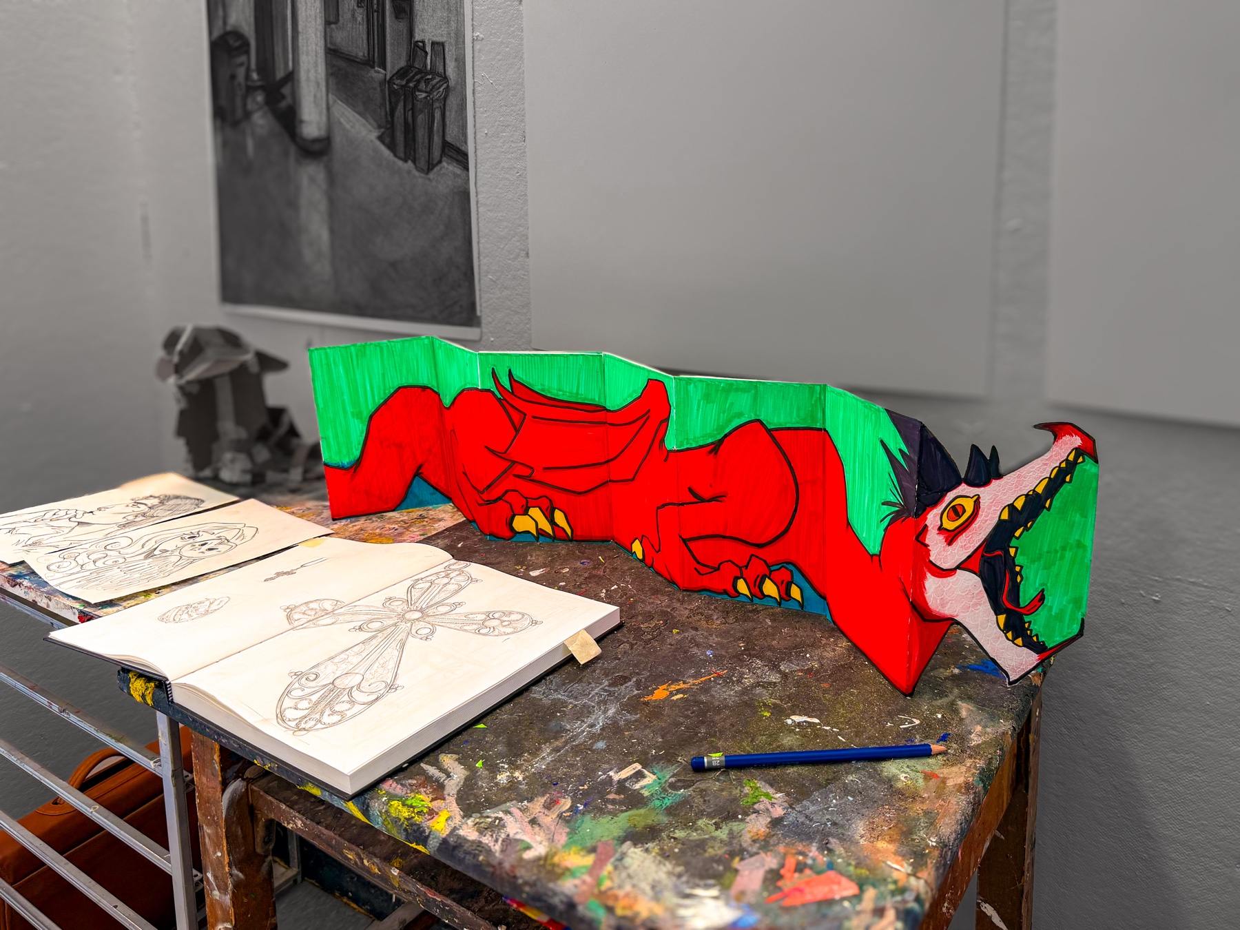 Red and green accordion-fold dragon zine made by a VASI student